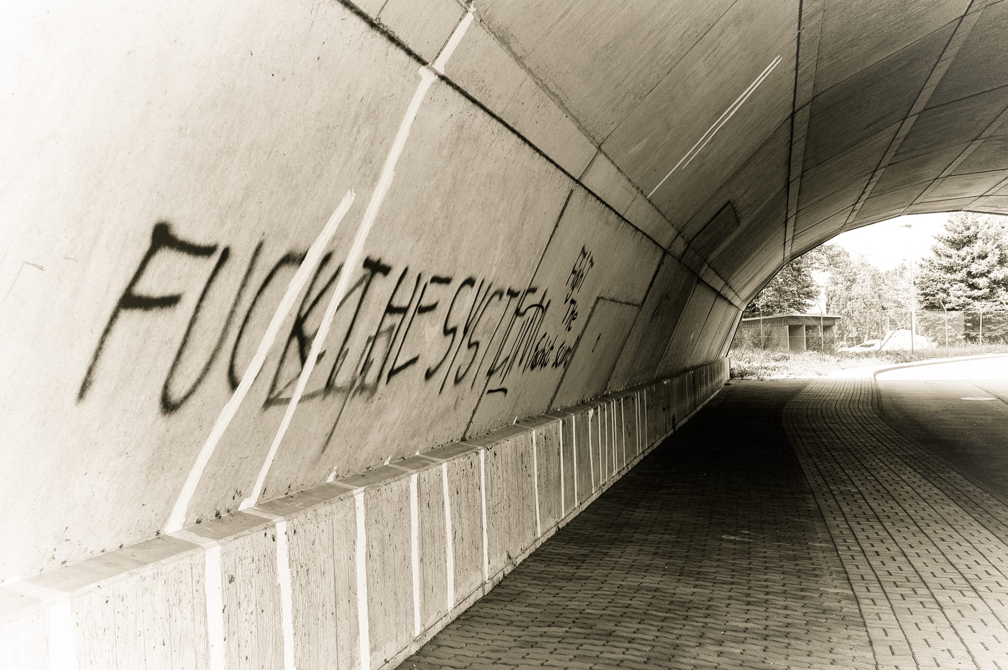 Eine Autobahnunterführung mit einem "Fuck The System" Graffiti